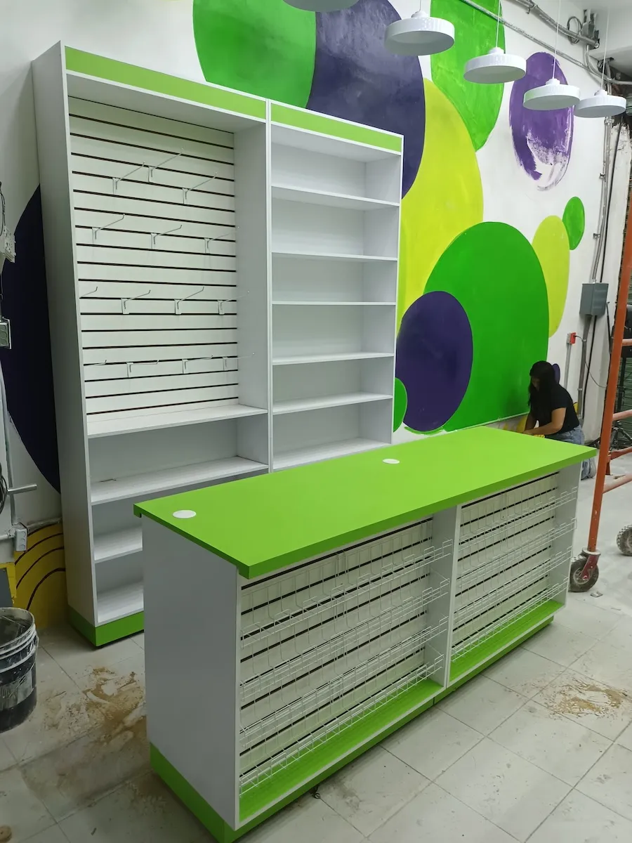 Estantería con panel ranurado y mostrador con cajoneras color verde