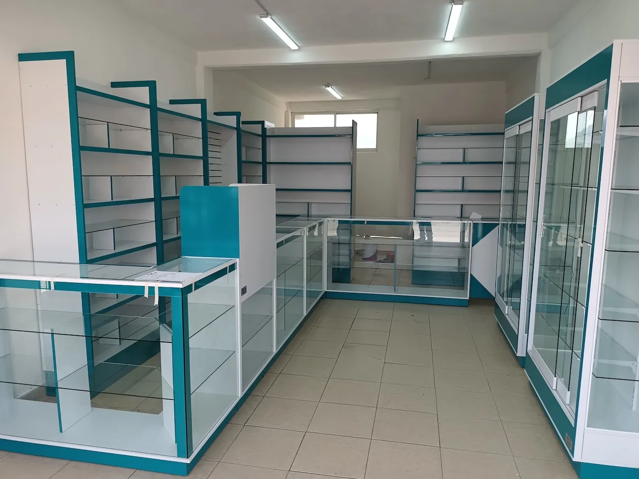 Góndolas metálicas color turquesa con entrepaños de cristal